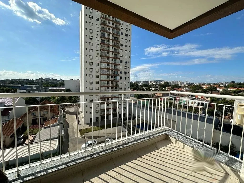 Sacada com sol da manhã, grade e vista do bairro